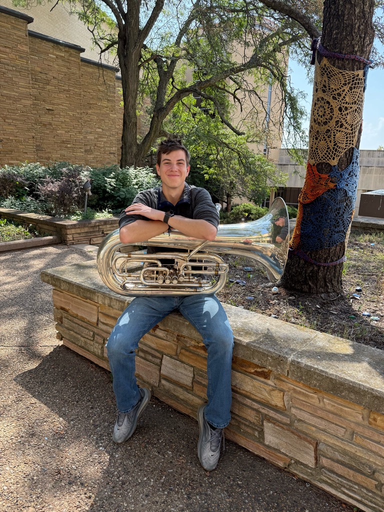Jack Stutler sitting outdoors with his tuba